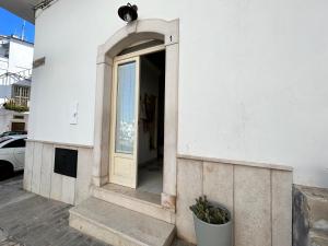 eine Tür in einem weißen Gebäude mit einem Fenster in der Unterkunft Minimà Peschici in Peschici