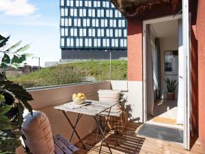 d'un balcon avec une table et une vue sur un bâtiment. dans l'établissement Sanders Charm - Endearing Two-Bedroom Apartment with Shared Garden, à Copenhague
