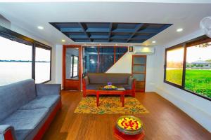 - un salon avec un canapé et une table dans l'établissement Kerala Boathouse, à Alappuzha
