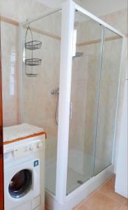 een douchecabine met een wasmachine in de badkamer bij My Holidays - Casa Laura in Domaso