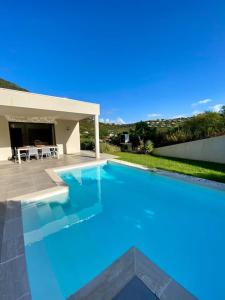 een blauw zwembad voor een huis bij Villa Cavalaire luxueuse & calme avec piscine in Cavalaire-sur-Mer