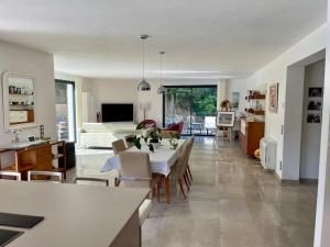 een keuken en een woonkamer met een tafel en stoelen bij Villa Cavalaire luxueuse & calme avec piscine in Cavalaire-sur-Mer