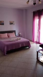 een slaapkamer met een bed met een paarse deken bij Evgenia Studios in Oud Epidauros