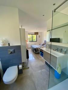 een badkamer met een toilet, een wastafel en een bed bij Villa Cavalaire luxueuse & calme avec piscine in Cavalaire-sur-Mer
