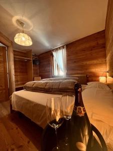 a bedroom with a bed and two glasses of wine at Sasso Nero in Chiesa in Valmalenco