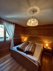 a bedroom with a bed and a chandelier at Sasso Nero in Chiesa in Valmalenco