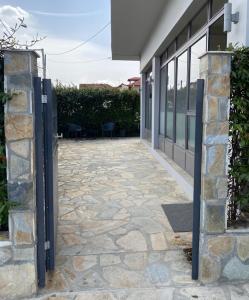einen Eingang zu einem Gebäude mit einem steinernen Gehweg in der Unterkunft Oikos Olympos in Ágios Spyrídon