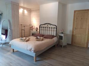 a bedroom with a bed with two baskets on it at La Marmotte de la Tour in Hermillon