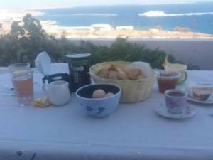 - une table avec un panier d'œufs et de tasses à café dans l'établissement Galini view, à Frý