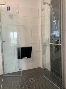 y baño con ducha y puerta de cristal. en de Glemfisk, barrierefrei, en Dorum-Neufeld