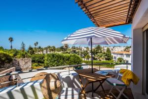 a patio with a table and an umbrella at Beach Park Apartments in Luz