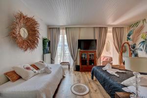 a hotel room with two beds and a television at Hotel Des Artistes in Tarascon