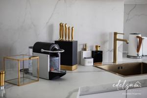 encimera de cocina con electrodomésticos de oro y fregadero en Paris Parc Monceau by Edelsam en París