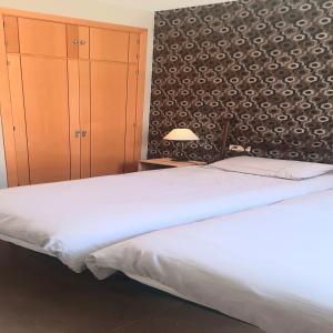 マラガにあるApartamento Casas de Camposの白いベッドと壁が備わるベッドルーム1室が備わります。