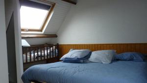 um quarto com uma cama com almofadas e uma janela em Gite des confitures à Lanvéoc-Crozon em Lanvéoc