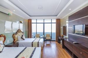 um quarto de hotel com duas camas e uma televisão de ecrã plano em Phuong Hoang Hotel em Thanh Hóa