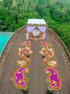 un grupo de serpientes coloridas en un puente de madera en Kastara Resort en Ubud