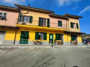 a yellow and green building with chairs in front of it at Il Giardino dei Pavoni in Soviore +26 photos
