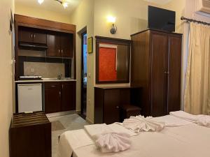 Una habitación de hotel con una cama y una cocina. en ADG Luxurious Apartments, en Leptokarya