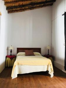 um quarto com uma cama com duas mesas de cabeceira em Casa Mora em Encinasola