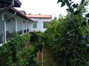 uma casa obscurecida por árvores e arbustos em Cumini Resort em Anuradhapura