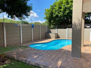 a swimming pool in a backyard with a fence at Christa's Place 897 in Pretoria