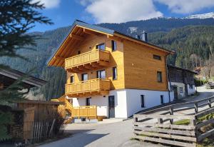 un edificio con balcones de madera en un lateral en Almliesl MAIS-700 en Maishofen