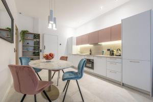a kitchen with a table and blue chairs at Residence Meynadier - apartments - New - AC - Wifi - Close Beach and Palais - LRA Cannes in Cannes