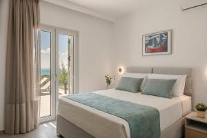 una camera con un grande letto e un balcone di Summertime Villas ad Argostoli