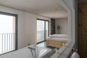 a bathroom with a bed and a bath tub and a sink at Berghotel Mettmen in Schwanden