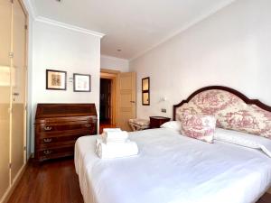 um quarto com uma grande cama branca e uma cómoda em Housingleón - Centro Colón em León