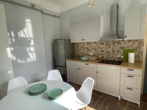 a kitchen with a white table and white chairs at Skyline Apartments in Rīga +20 photos