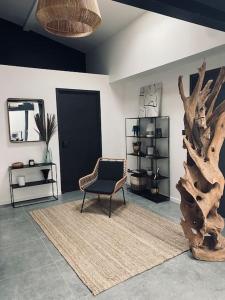 una habitación con una silla y un tronco de árbol en Maison de ville avec un charme atypique en Pontarlier