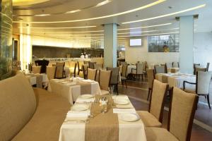 a dining room with white tables and chairs at Jaypee Siddharth in New Delhi