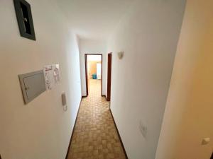 un pasillo con un largo pasillo con suelo de baldosa en Apartamento da Fonte en Figueira da Foz