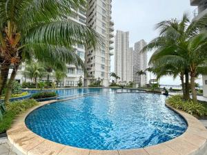 a large swimming pool with palm trees and buildings at Country Garden by Antlerzone in Johor Bahru