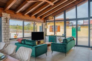 a living room with two green chairs and a television at Ferienhaus/HolidayHouse Smokvica **** in Rakalj in Rakalj