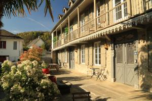 a building with a patio with a table and a bench at Maison Candela in Argelès-Gazost