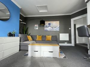 a living room with a gray couch and yellow pillows at Coastal Comfort, Seaside Flat in Margate