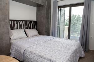 a bedroom with a bed and a large window at Sea View Frini Lefkada in Lefkada Town