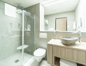 ein Badezimmer mit Waschbecken, Toilette und Dusche in der Unterkunft Bernstein Salzlandcenter in Staßfurt