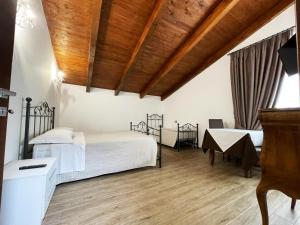 1 dormitorio con 2 camas y techo de madera en Tenuta Morrone, en Pertosa