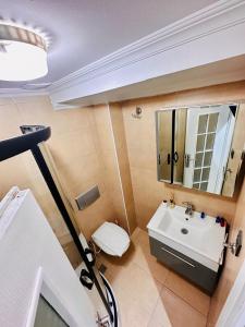 a bathroom with a sink and a toilet and a mirror at Elegance Aparts Cihangir in Istanbul