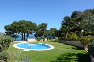 una piscina en un patio con césped y árboles en Ava Senia 4-1, en Begur