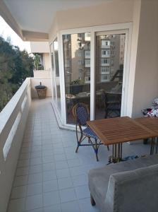 eine Terrasse mit einem Holztisch und Stühlen auf dem Balkon in der Unterkunft 3 rooms and living room, centrally located, large apartment in Bayrakli