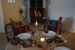 a table with two plates of food and a fireplace at Heidal Gjestgiveri AS in Nedre Heidal