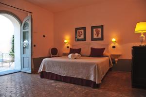 a bedroom with a large bed with orange walls at La Salina Hotel Borgo Di Mare in Lingua