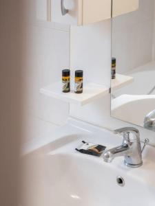 Baño blanco con lavabo y espejo en Apartment Santa Marina 6, en Asgourou