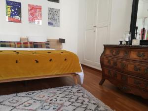 a bedroom with a yellow bed and a dresser at Escale citadine au centre d'Avignon, climatisation, appartement de charme, spacieux et lumineux in Avignon