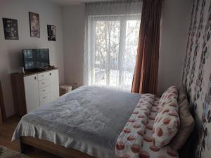 een slaapkamer met een bed en een raam bij Avantgarden1 .Apartament lux in Braşov